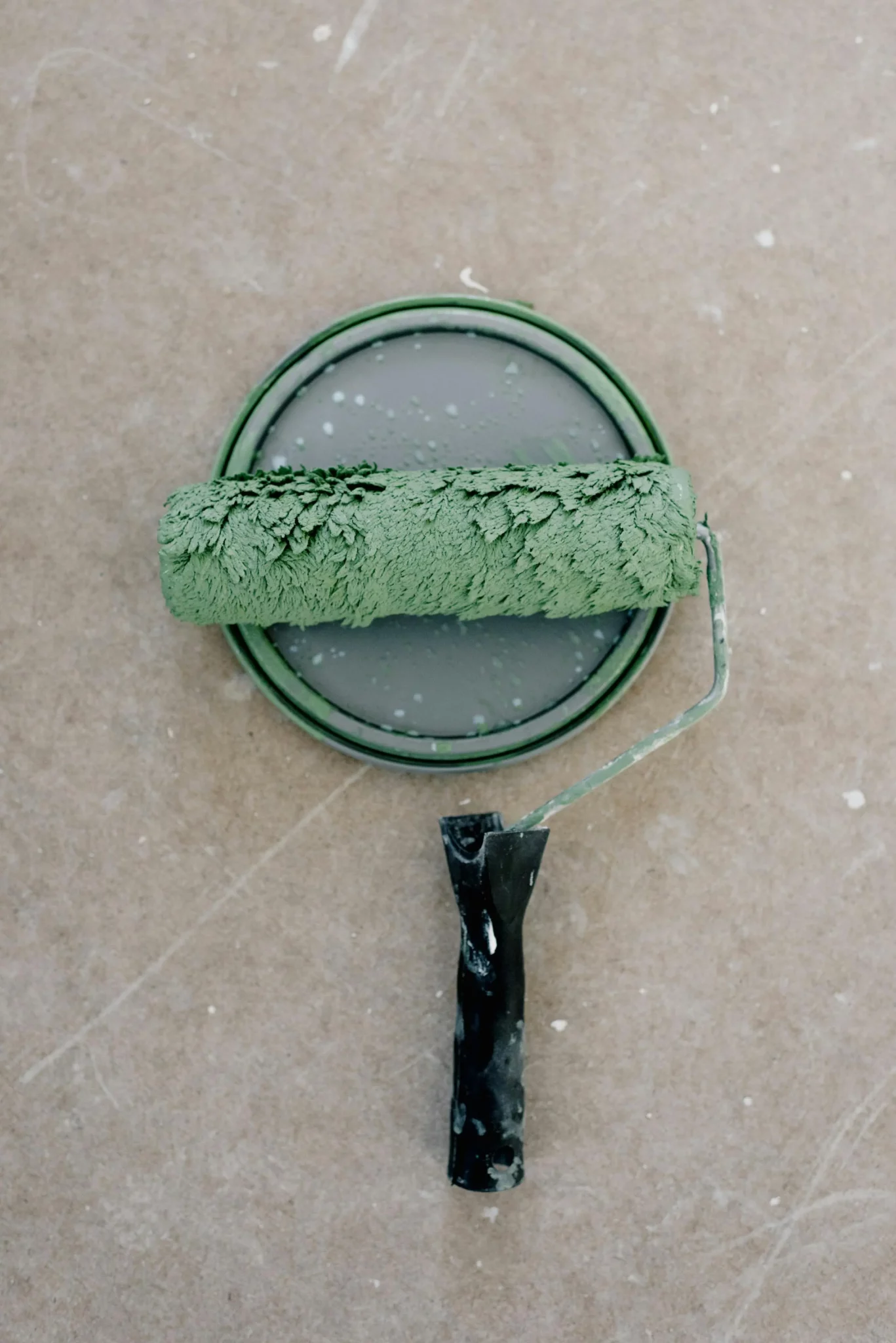 Rouleau à peinture vert et pot de peinture.
